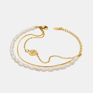 Gold layered bracelet with pearls, chain, and a circular charm.