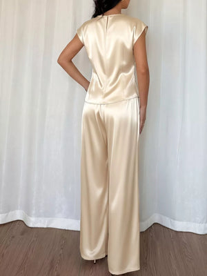 Champagne satin twist-front top with cap sleeves and flowing wide-leg pants.