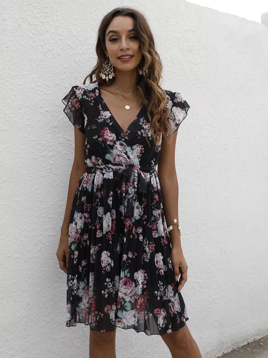 Black floral pleated dress with ruffle sleeves and a V-neck.