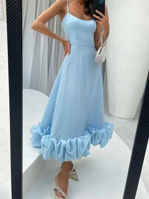 Light blue midi dress with spaghetti straps and a ruffled hem.