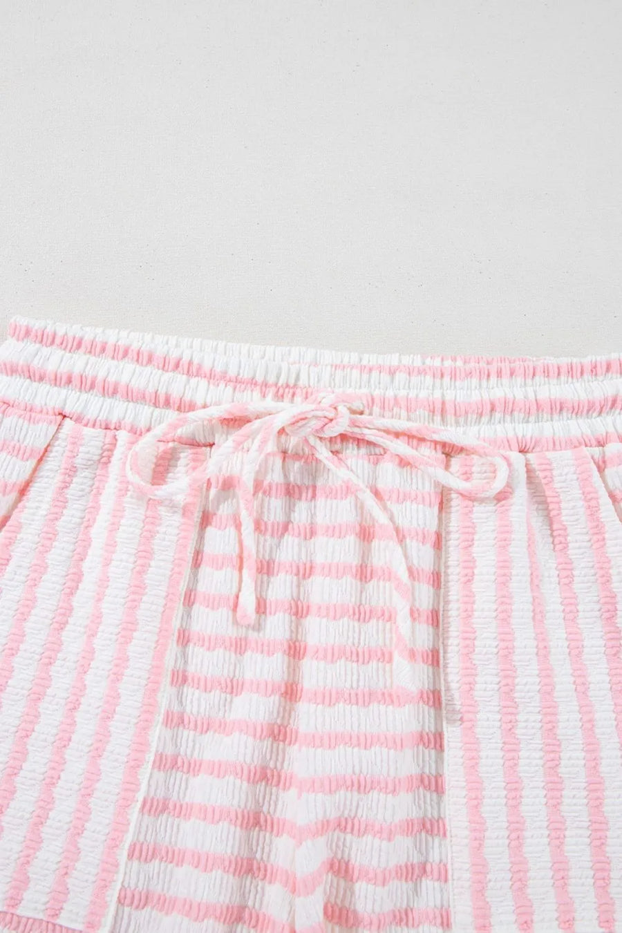 Textured stripe lounge shorts in blush pink and white with drawstring waist.