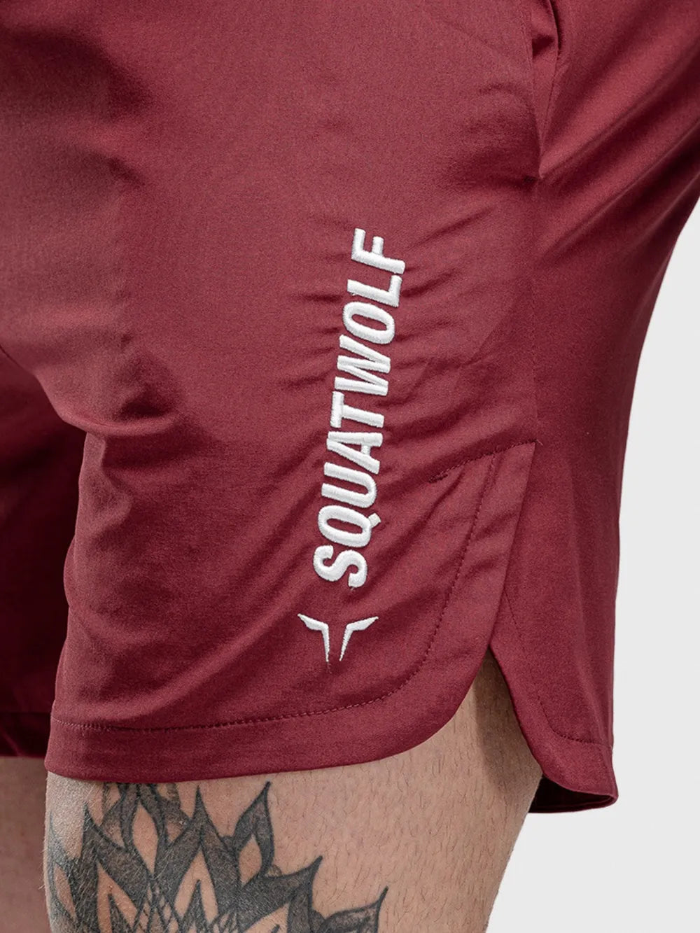 Burgundy performance shorts with split hem and white logo detail