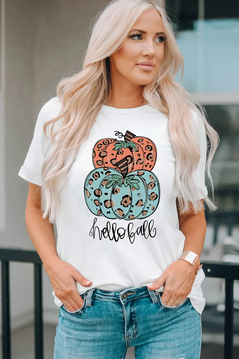 White t-shirt with stacked leopard print pumpkins and "hello fall" graphic.