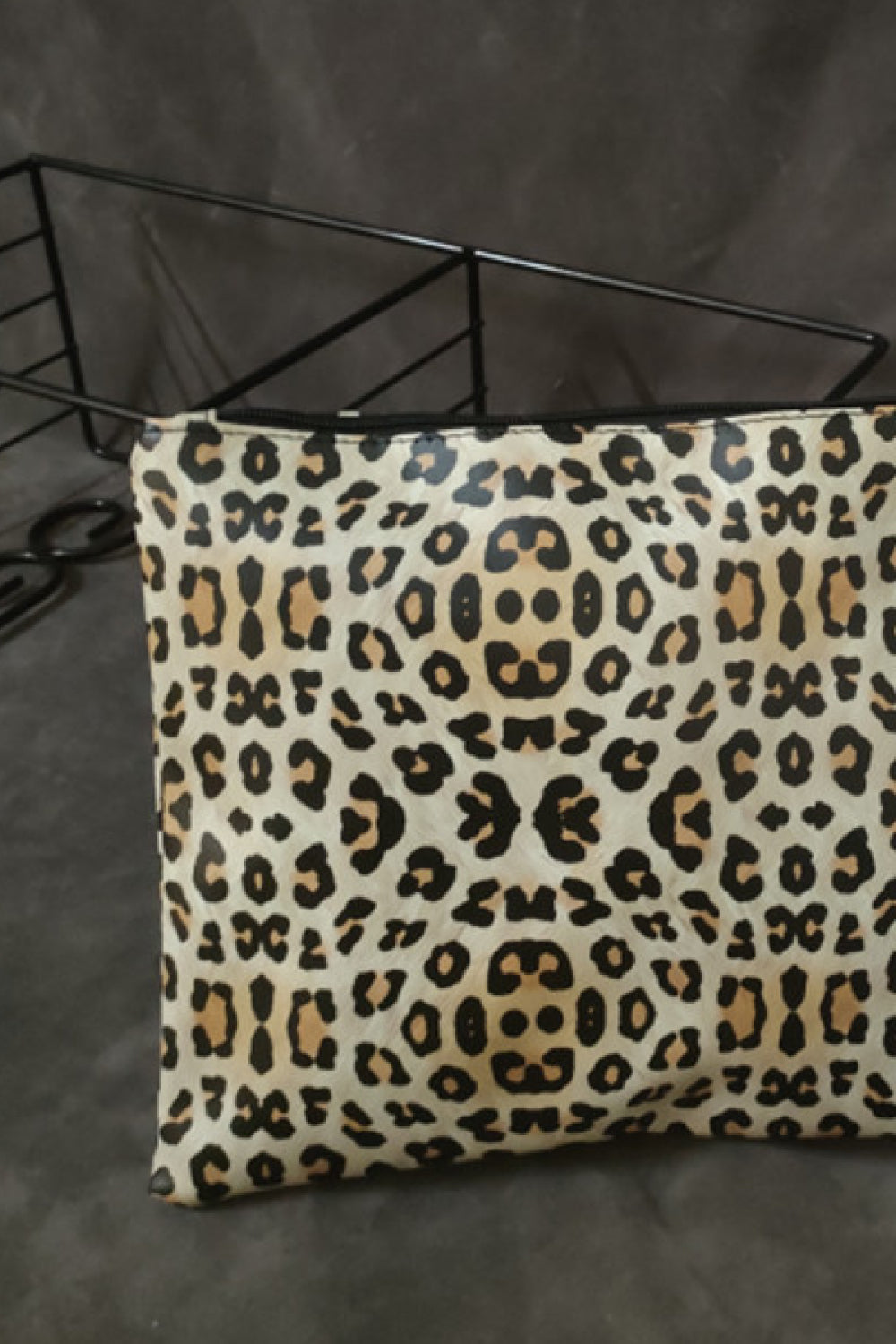 Leopard print zip-top clutch bag with black zipper detail.