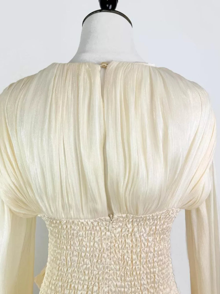 White ruffled mini dress with smocked corset waist detail and long sleeves.