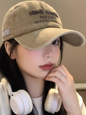 Khaki washed baseball cap with embroidered text and side patch