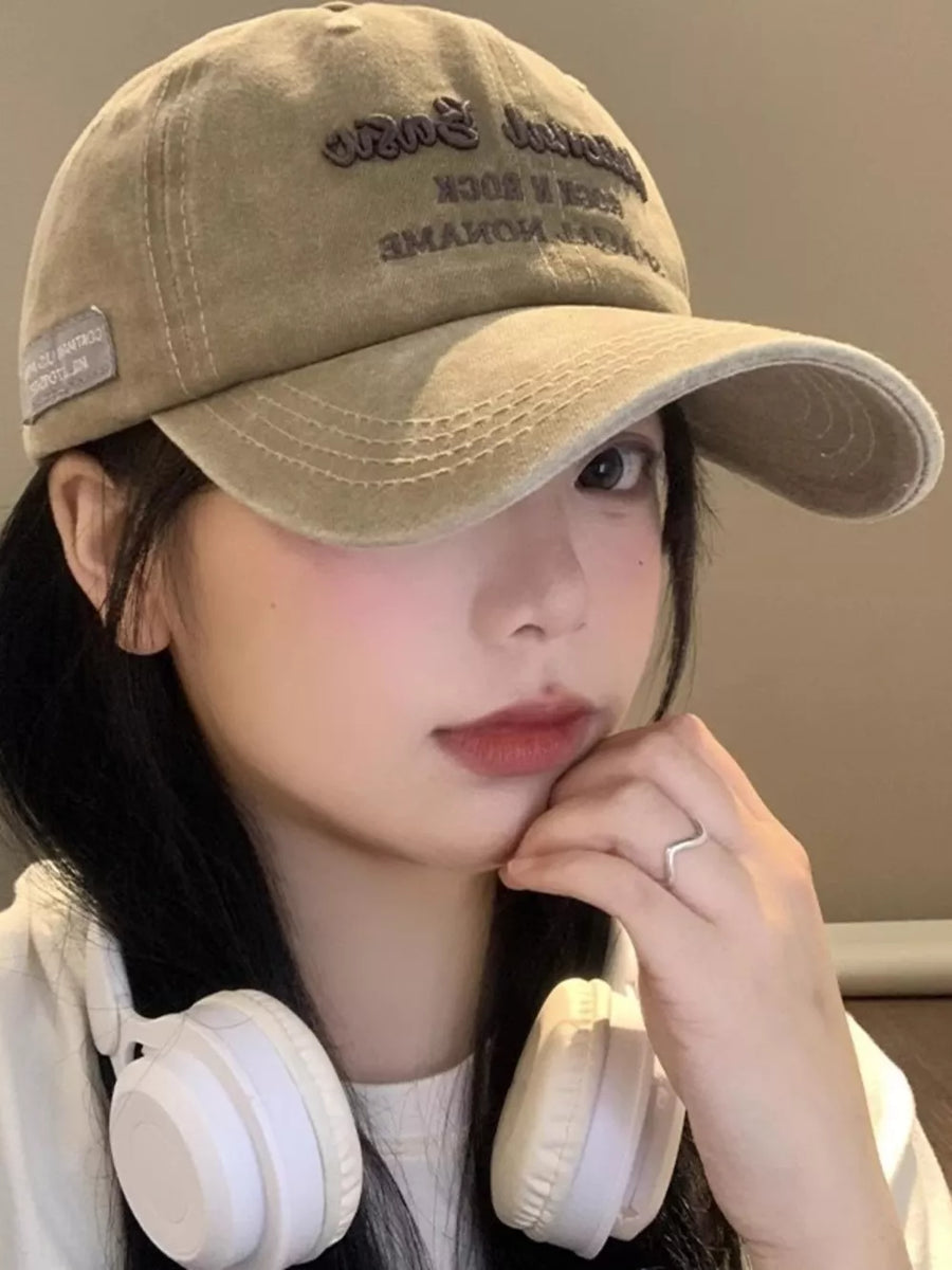 Khaki washed baseball cap with embroidered text and side patch