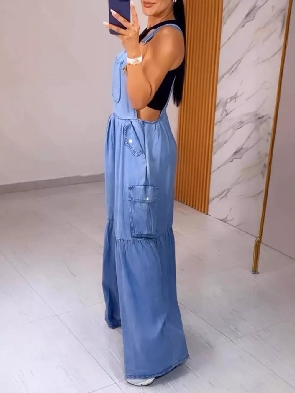 Blue denim wide-leg overalls with cargo pockets and tiered hem detail.