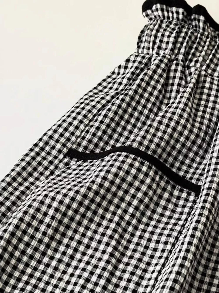 High-waisted wide-leg gingham pants with black trim detail and elastic waistband.