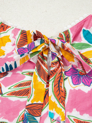 Print bell sleeve mini dress with a colorful floral and leaf pattern and a tie-neck detail.