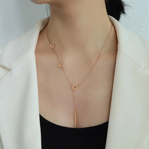 Rose gold Love Letter pendant necklace with bar drop detail.