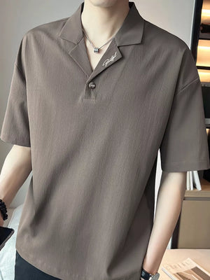 Taupe cotton polo shirt with embroidered detail and buttoned collar.