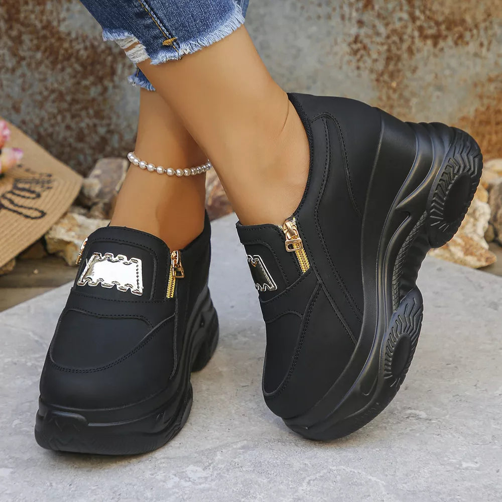Black round toe platform sneakers with side zippers and gold accents.