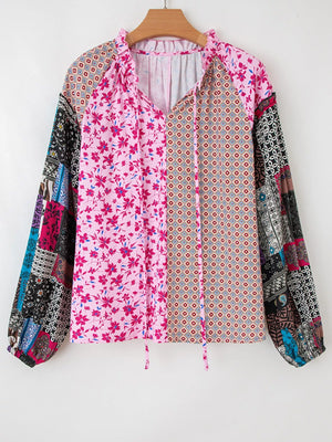 Boho patchwork print blouse with floral and geometric patterns, tie neck, and bubble sleeves.