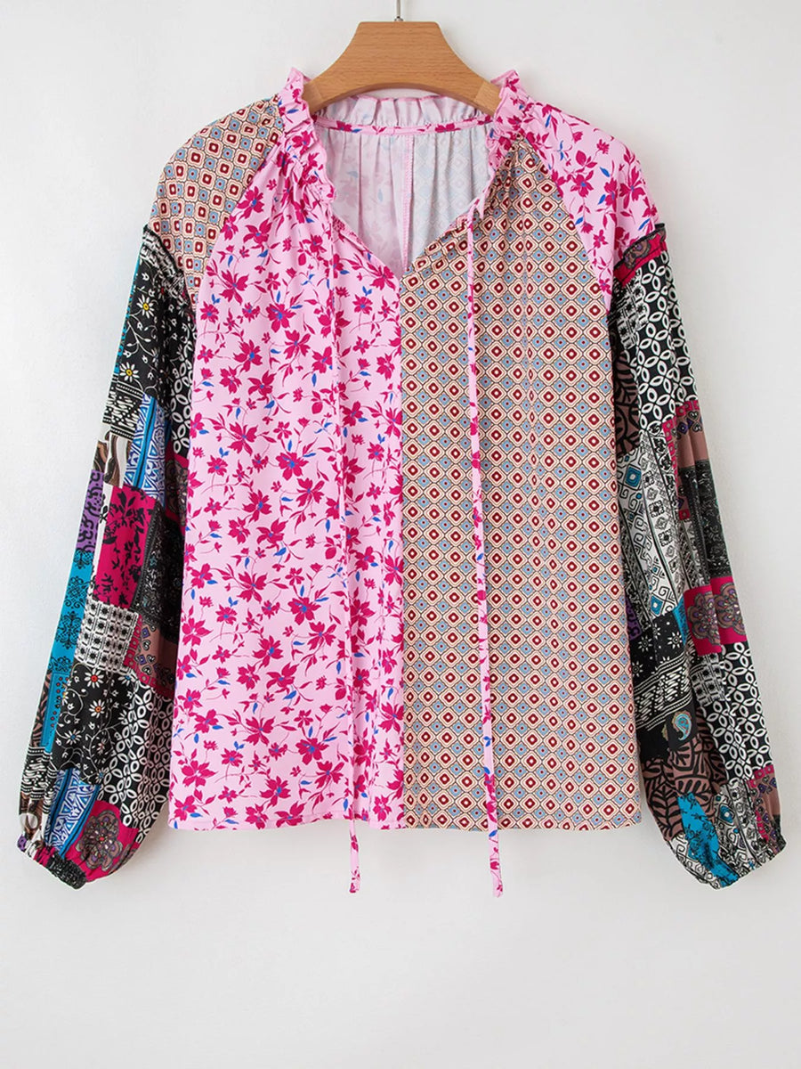 Boho patchwork print blouse with floral and geometric patterns, tie neck, and bubble sleeves.