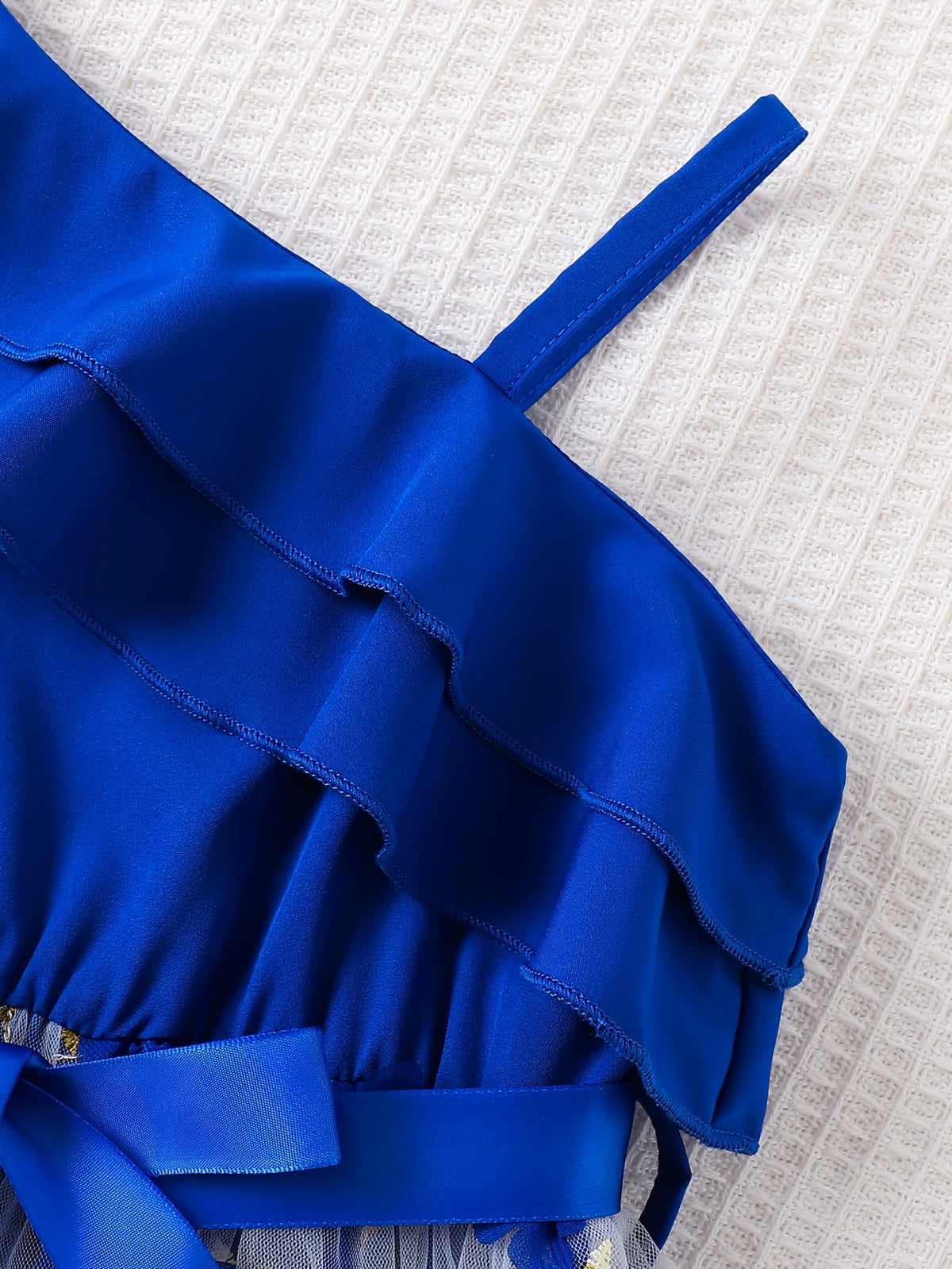 Royal blue asymmetrical ruffled toddler dress with embroidery detail and sash.