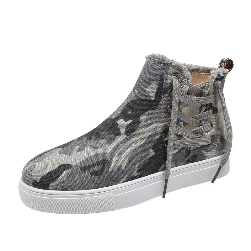 Green camouflage canvas zip-up sneaker booties with frayed edges and lace-up detail.