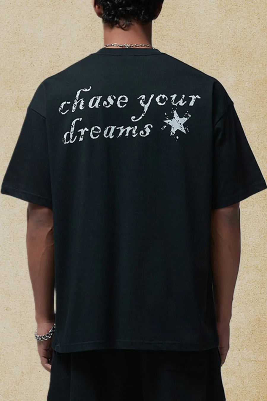 Black graphic t-shirt with white "chase your dreams" text and star graphic on back.