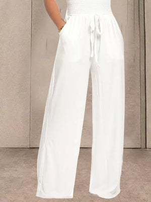 White wide leg pants with smocked waist and drawstring tie, featuring pockets.