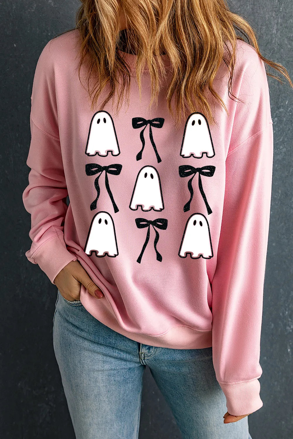 Blush pink sweatshirt with a ghost and bow graphic pattern