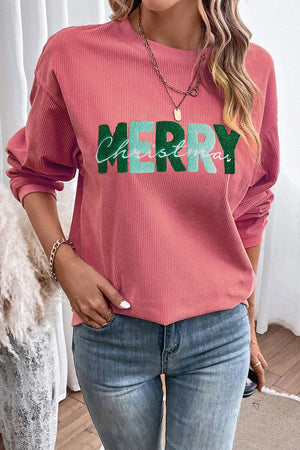 Textured corduroy sweatshirt in burnt coral with green and teal "Merry Christmas" graphic.