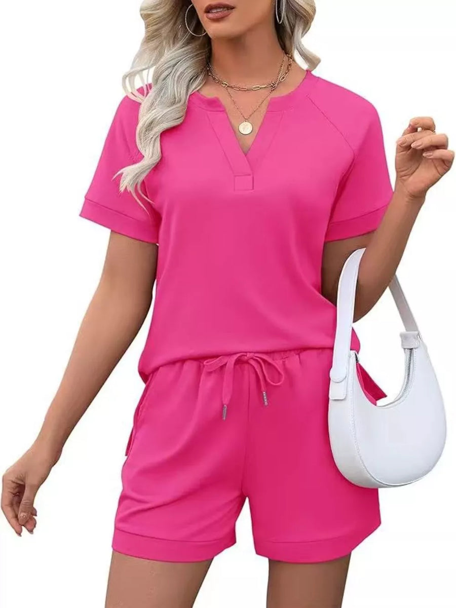 Fuchsia pink two-piece set with drawstring shorts and V-neck top with pockets.