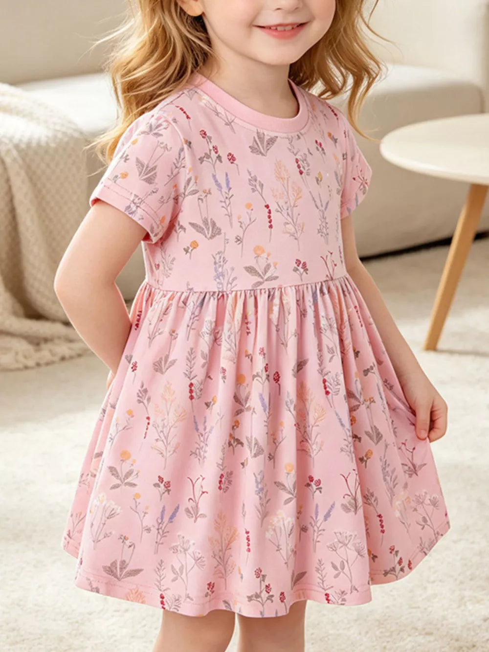 Children's pink floral print a-line dress with short sleeves and a gathered waist.