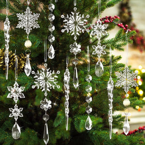Transparent acrylic icicle and snowflake Christmas ornaments hang on a tree.