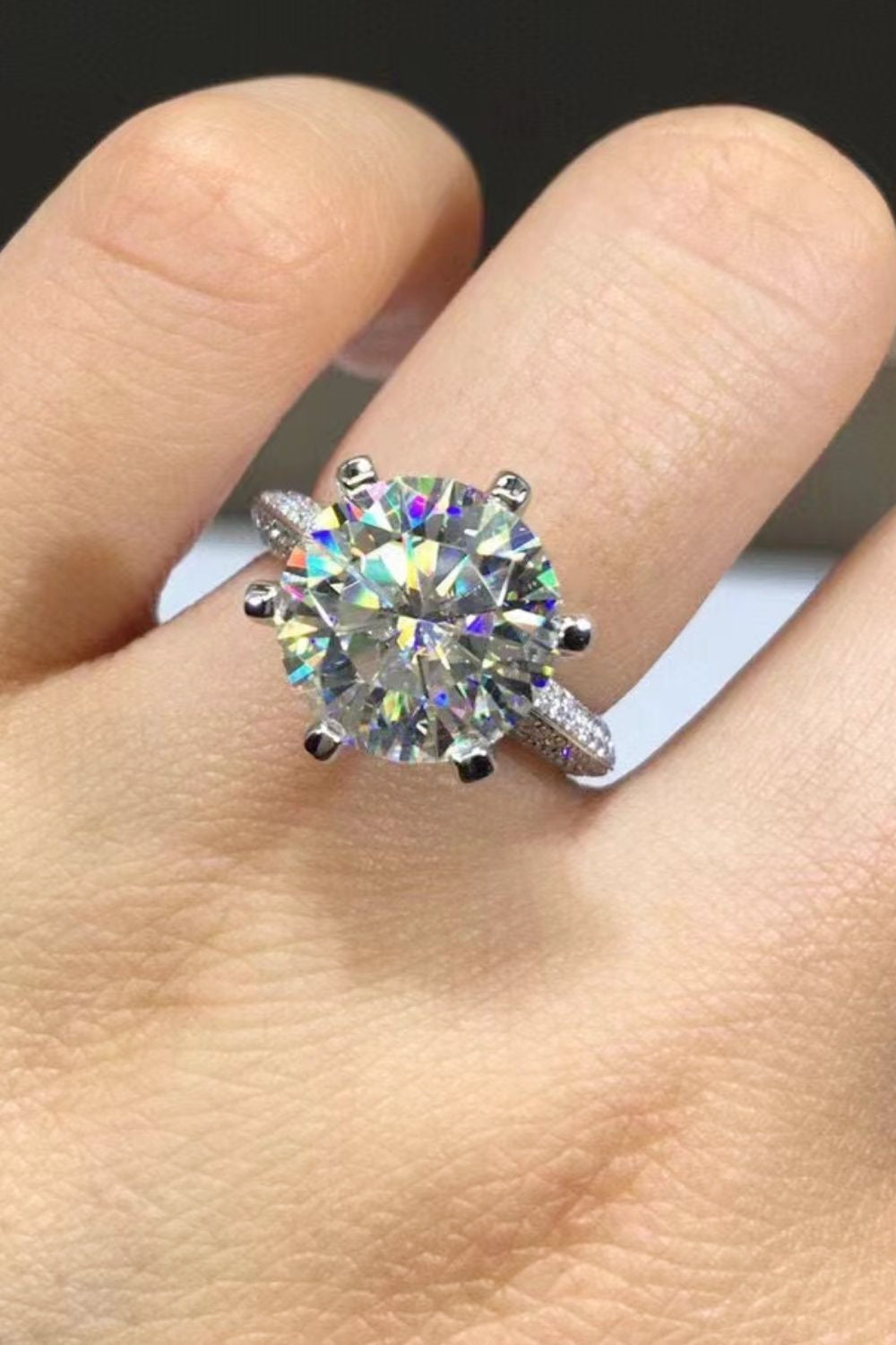 Silver pavé band moissanite solitaire ring with a large, round-cut center stone.