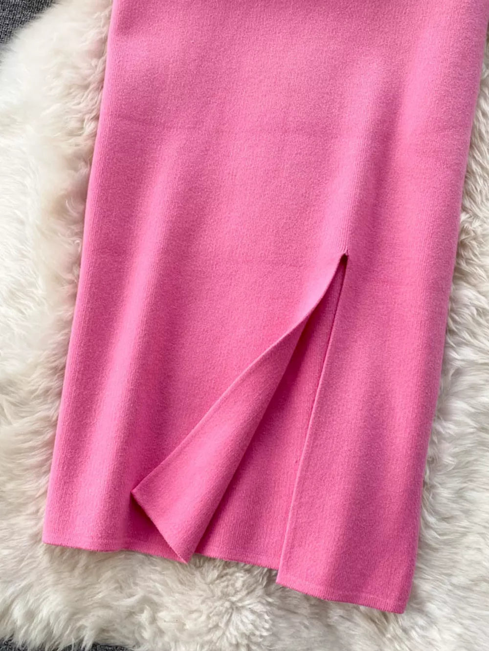 Pink knit midi skirt with a side slit detail.