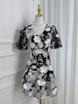 Black dress with white floral embroidery and sheer puff sleeves