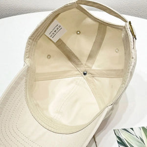Cream baseball cap interior with 100% cotton tag and adjustable strap