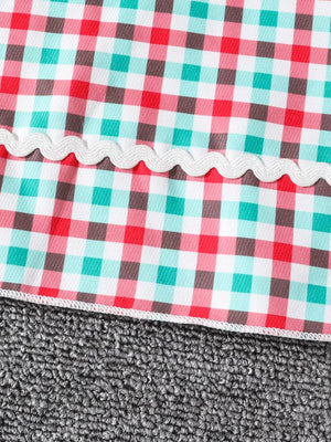 Festive plaid dress for little girls in multicolor gingham with white ric rac trim.