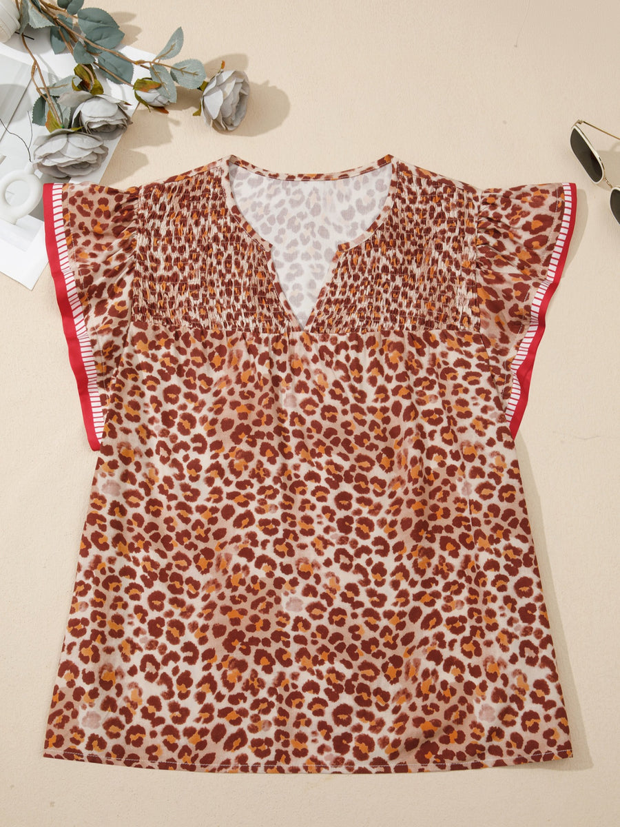 Smocked ruffled print blouse with V-neck and short sleeves in animal print.