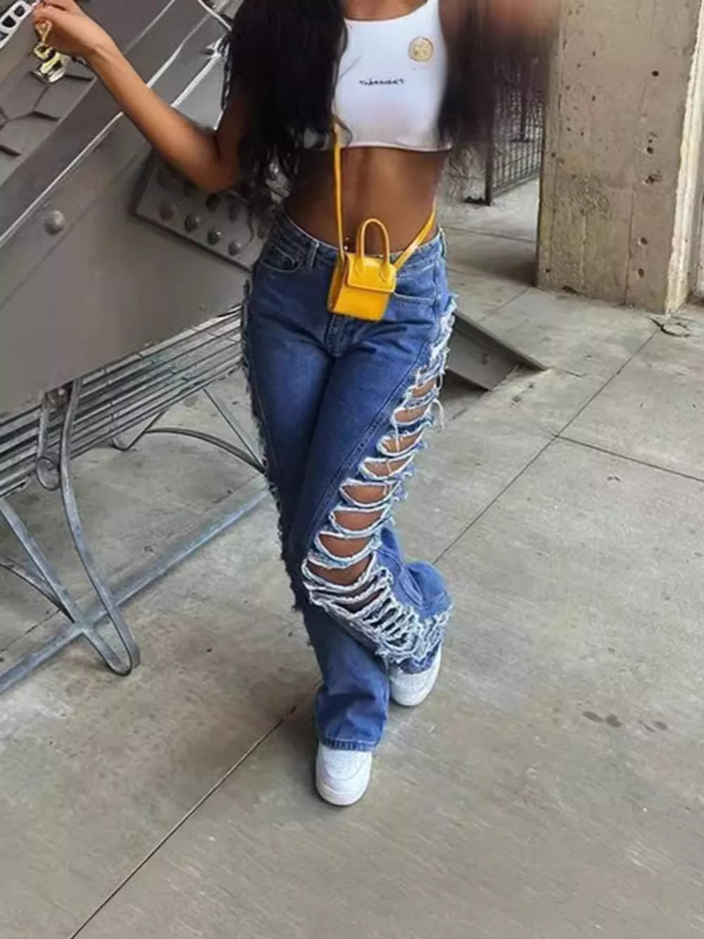 Blue denim jeans with distressed side cutouts and lace-up detail.