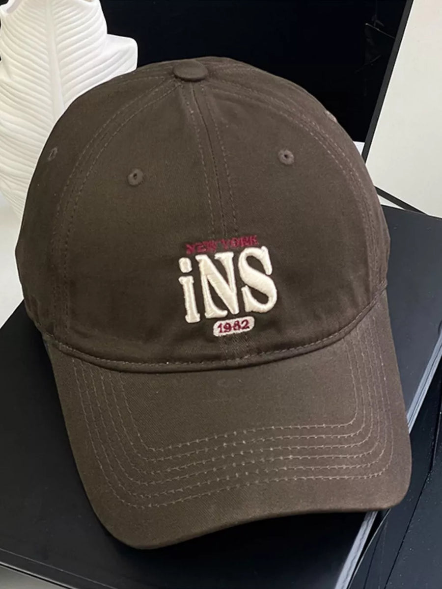 Brown baseball cap with embroidered "INS" and "1982" detail