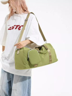 Green duffle bag with detachable pouch and tan strap.