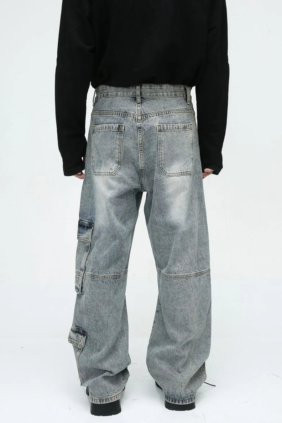 Medium wash wide leg cargo jeans with utility pockets and a relaxed fit.