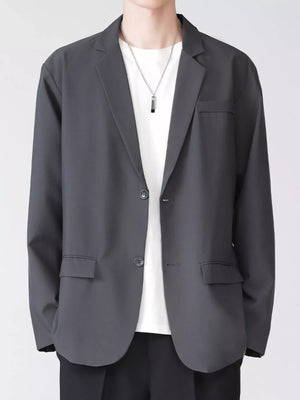 Men's grey lapel collar button up blazer with two buttons and flap pockets.