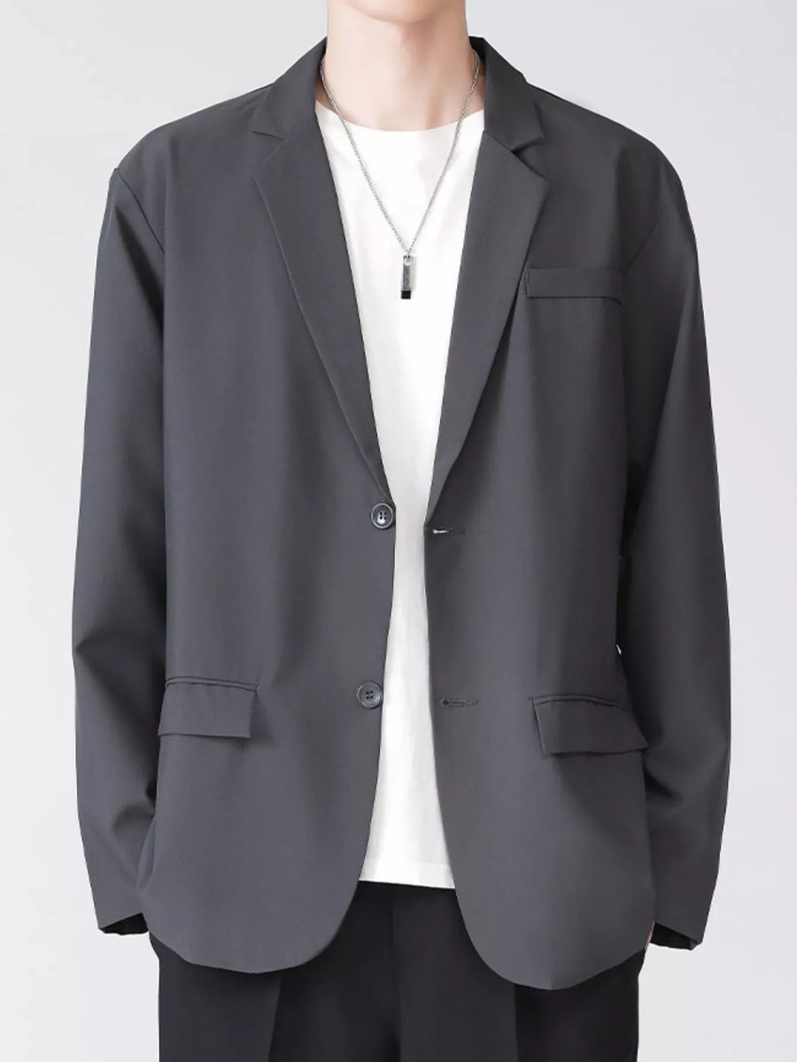 Men's grey lapel collar button up blazer with two buttons and flap pockets.