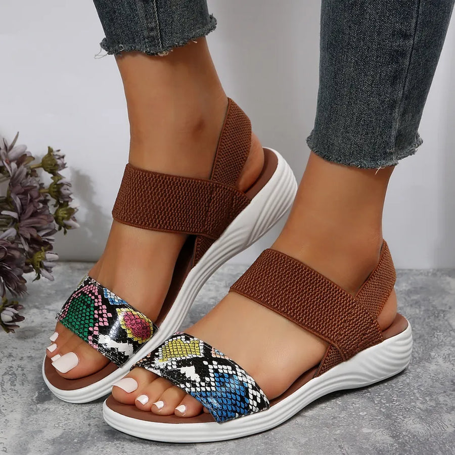Geometric print elastic strap sandals with brown elastic bands and white soles.