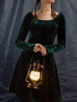 Green velvet long sleeve a-line gown with a round neckline.