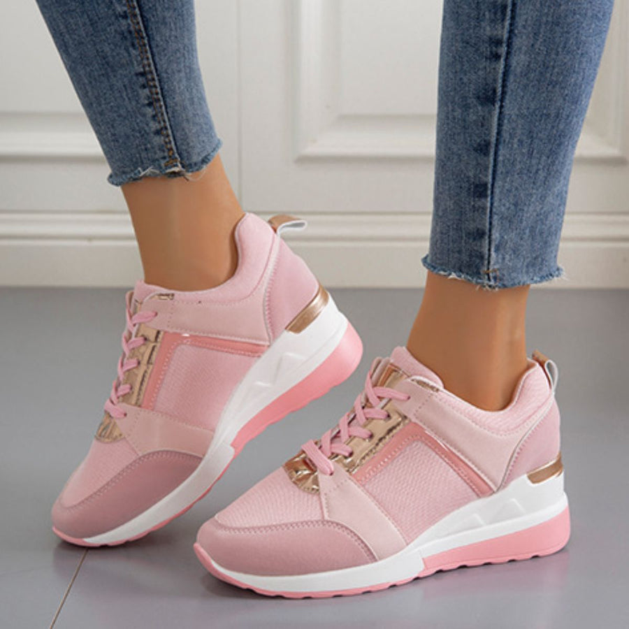 Pink lace-up wedge sneakers with metallic accents and a white sole.