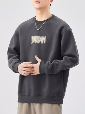 Oversized dark gray crew-neck sweatshirt with "DREAM" graphic print.