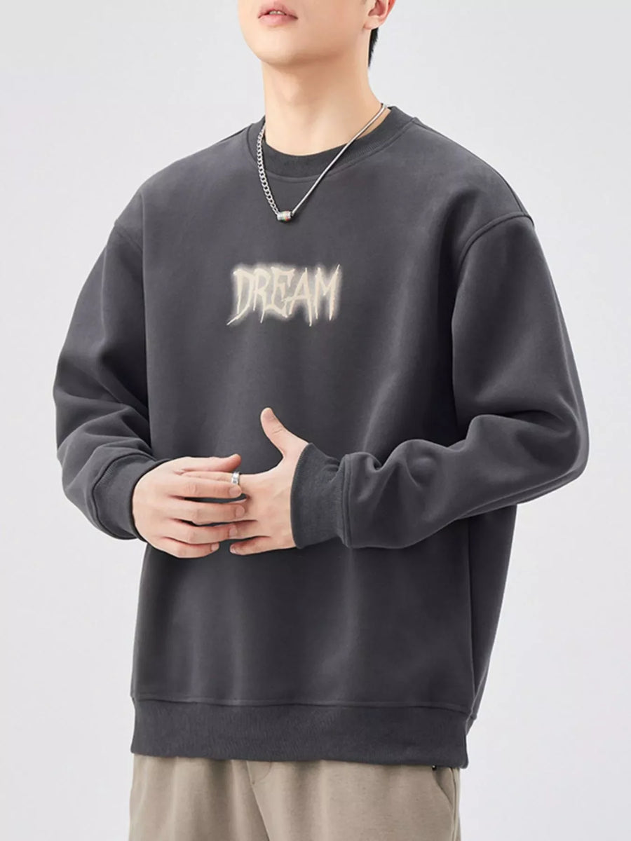 Oversized dark gray crew-neck sweatshirt with "DREAM" graphic print.