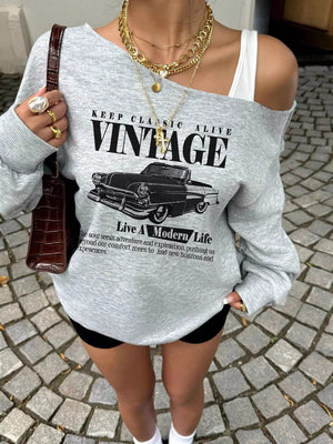 Grey oversized sweatshirt with asymmetrical neckline and vintage car graphic.