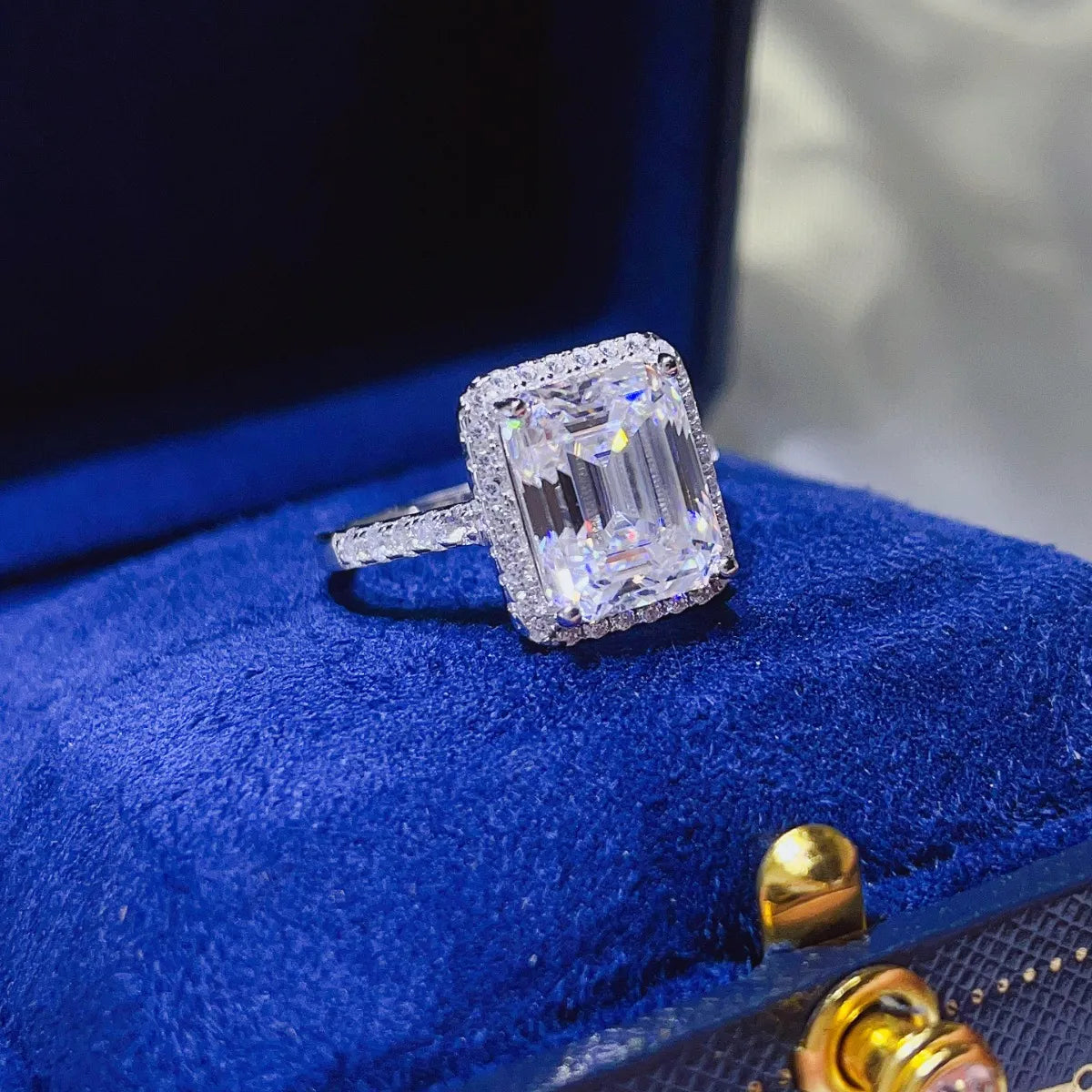 Emerald cut moissanite halo ring in sterling silver with pave band.