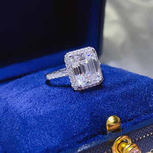 Emerald cut moissanite halo ring in sterling silver with pave band.