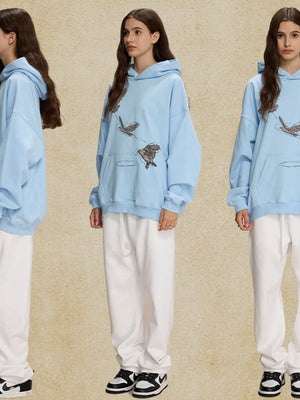 Light blue relaxed fit hoodie with embroidered birds and a front pocket.
