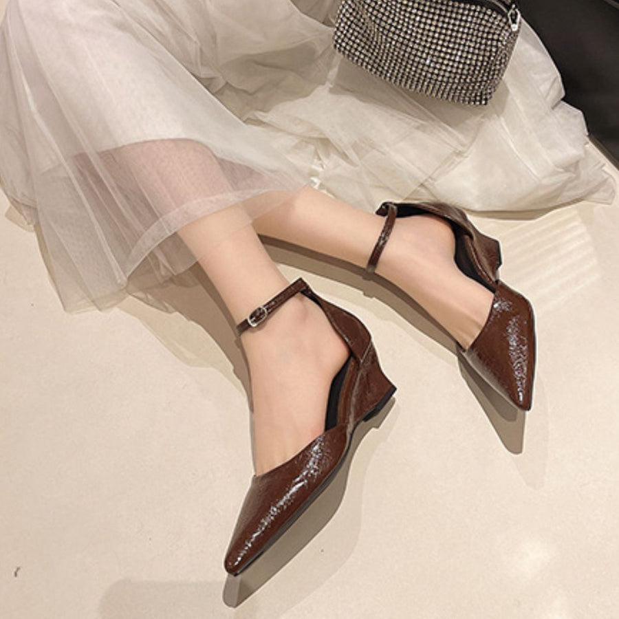 Brown pointed-toe ankle strap wedge heels with adjustable buckle.